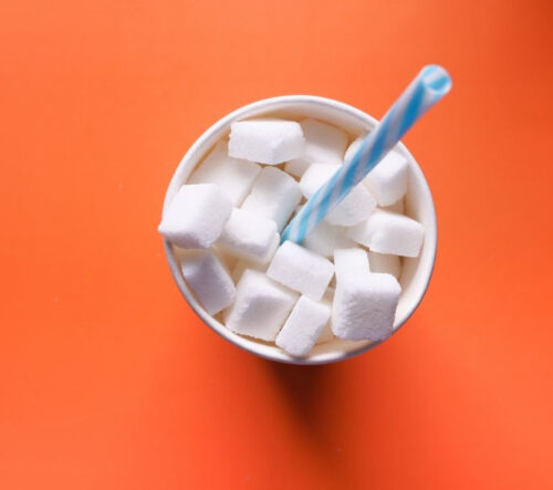 cup of sugar cubes with a straw