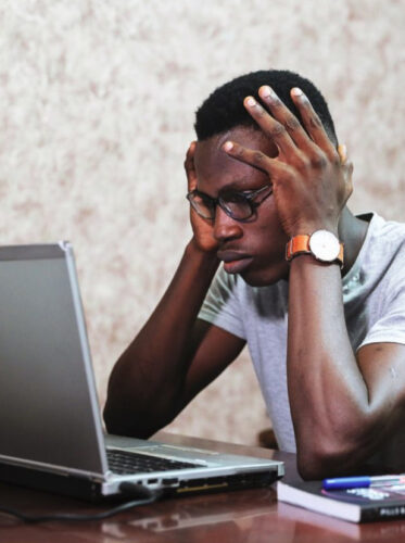 stressed out man sitting in front of computer