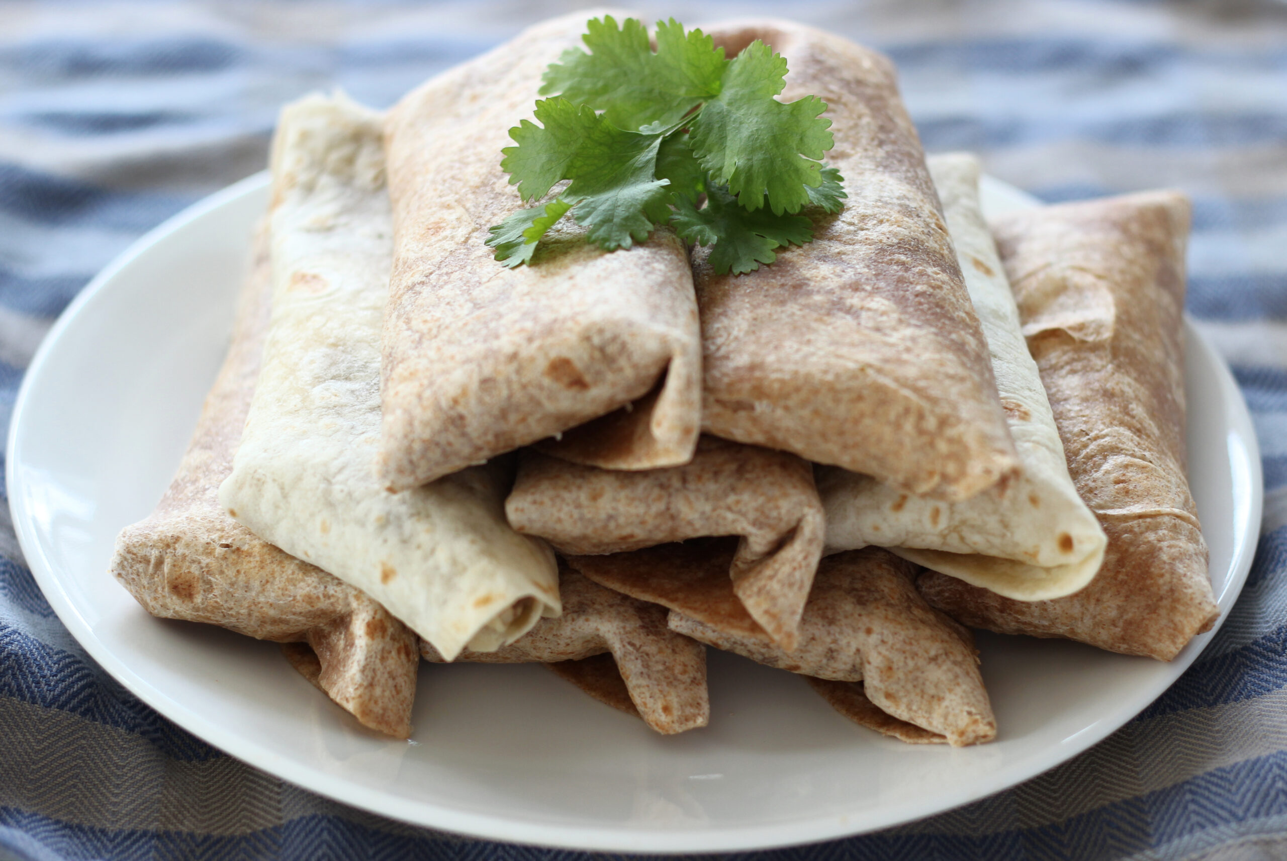 Vegetarian bean burritos on plate with cilantro