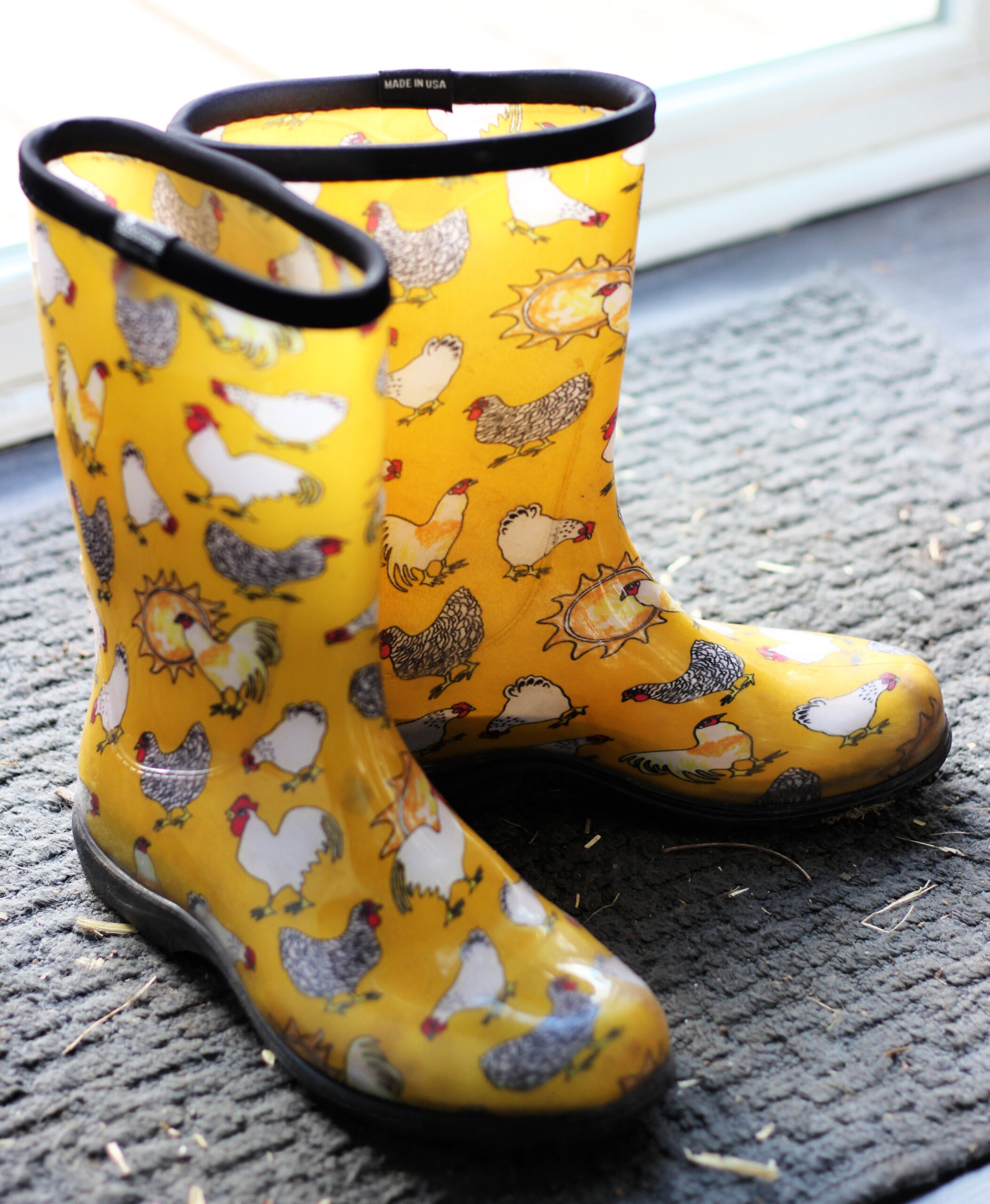 Yellow rain boots with pictures of chickens on them