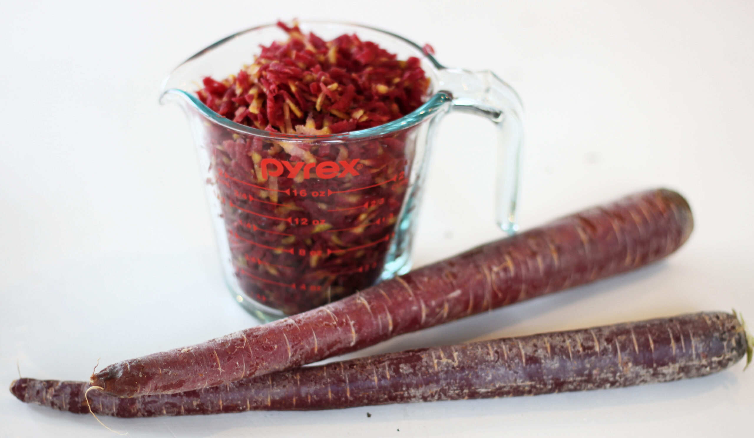 Purple carrots next to shredded carrots