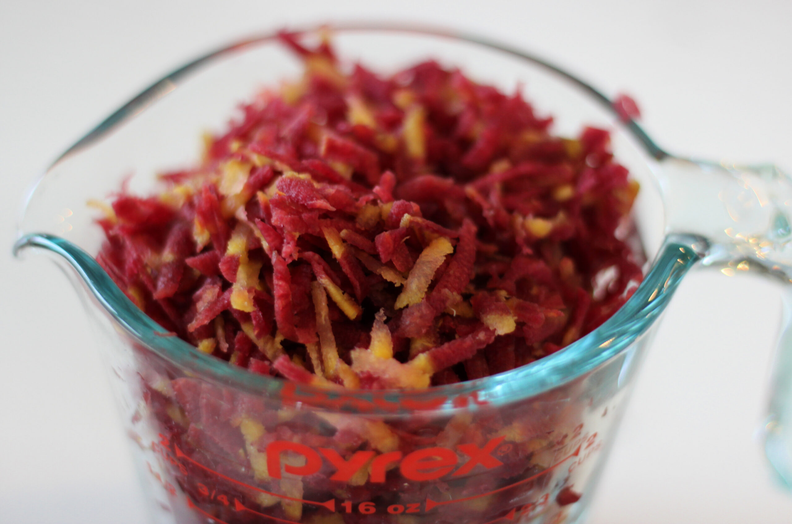 Measuring glass filled with shredded purple carrot