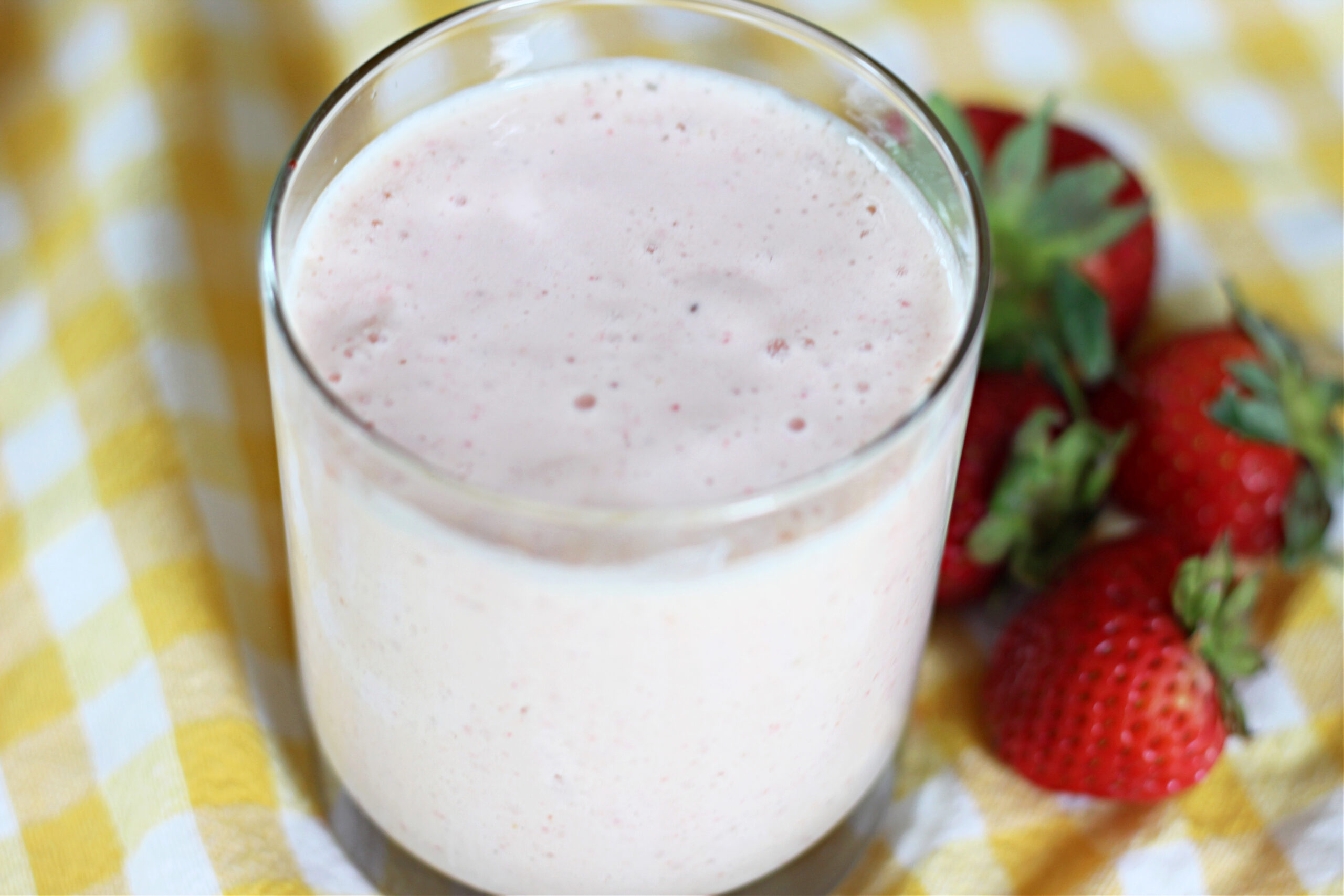 Summer fruit & yogurt smoothie next to strawberries