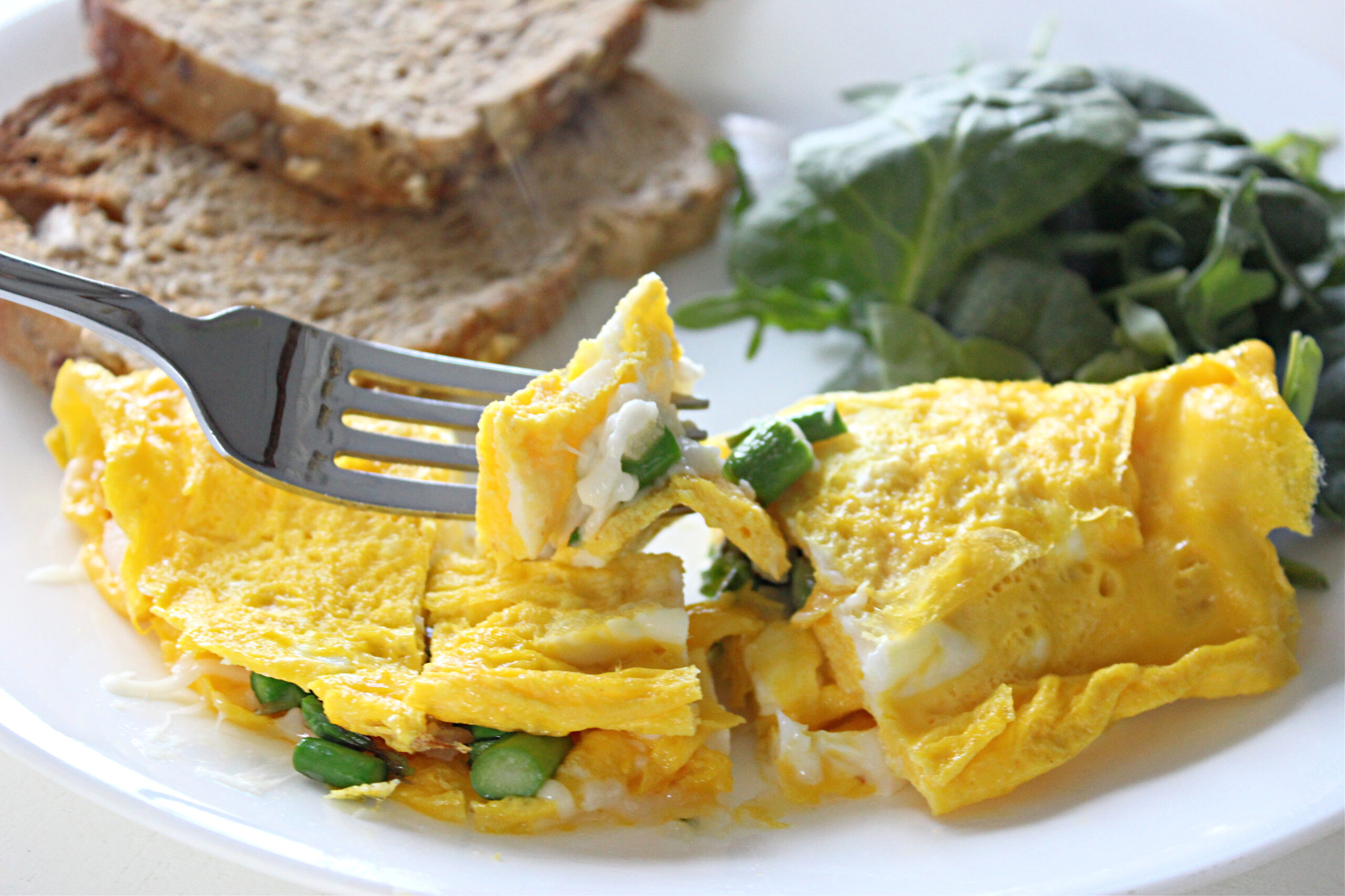 Omelet on plate with vegetables and toast