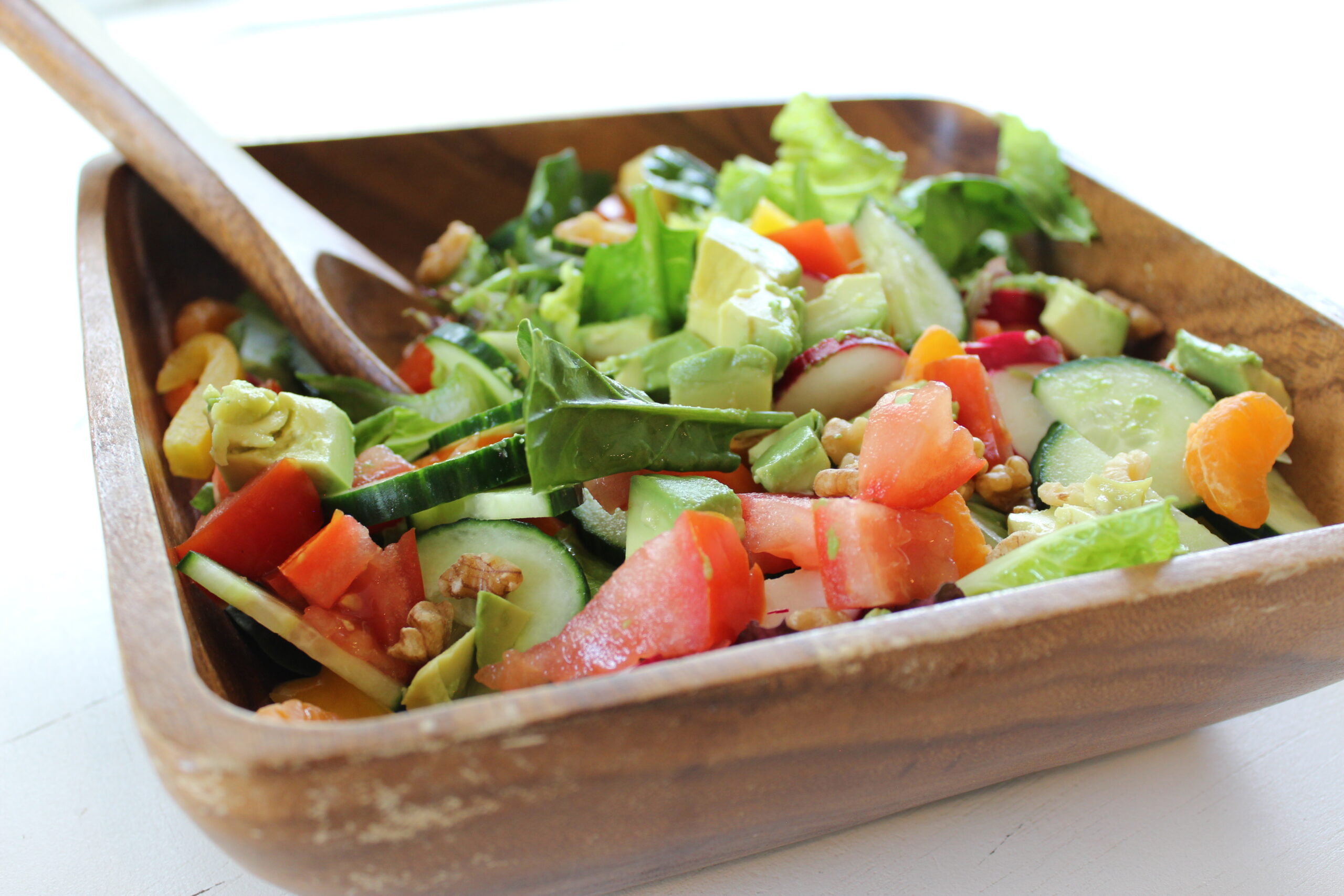 Salad in a wooden bowl with serving spoon