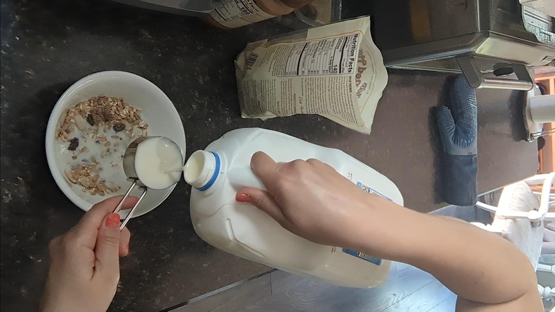 Pouring milk into a bowl of muesli