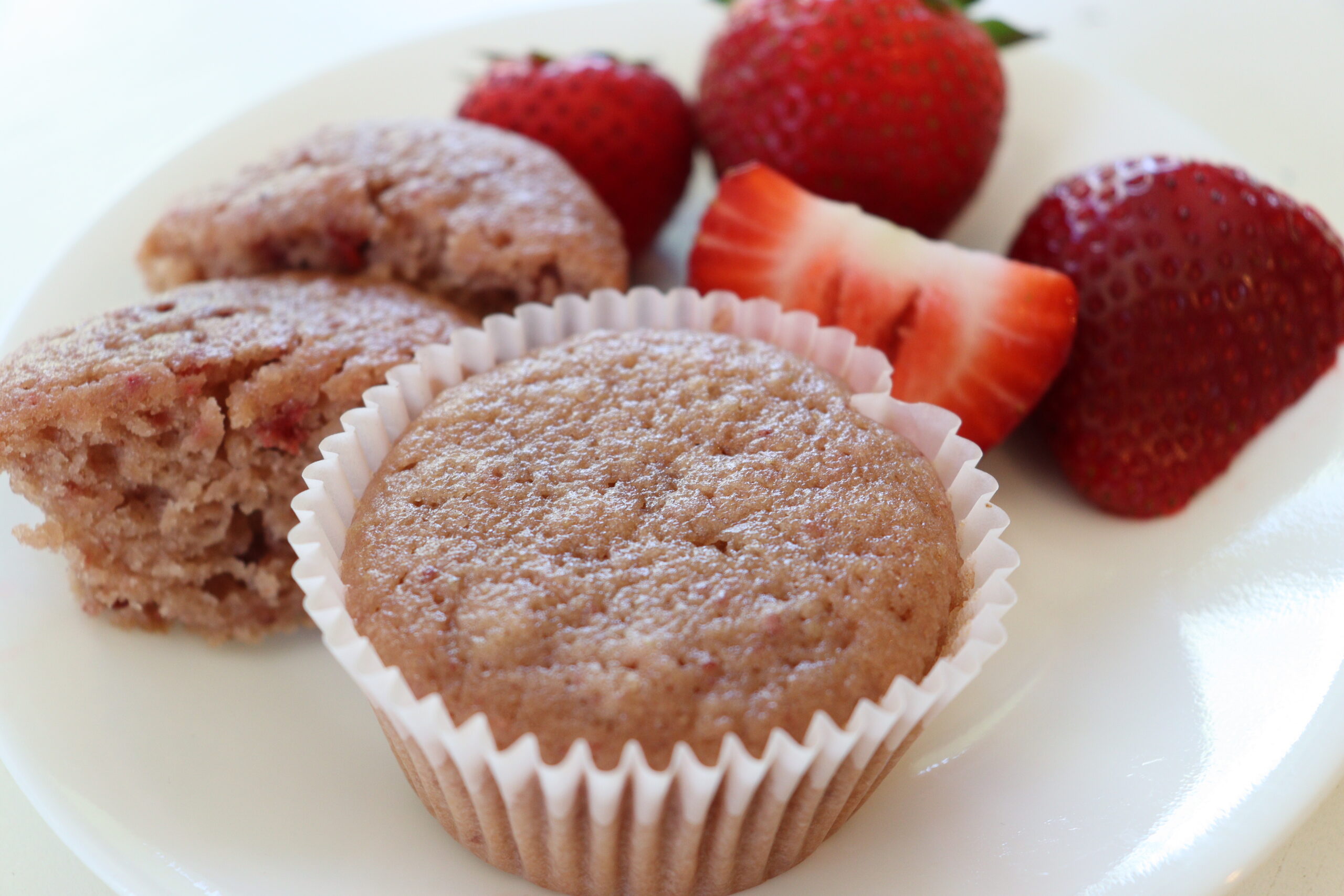 Strawberry muffins on plate with fresh strawberries