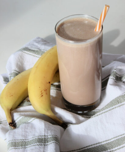 chocolate peanut butter banana smoothie in a glass and mug of dark hot chocolate